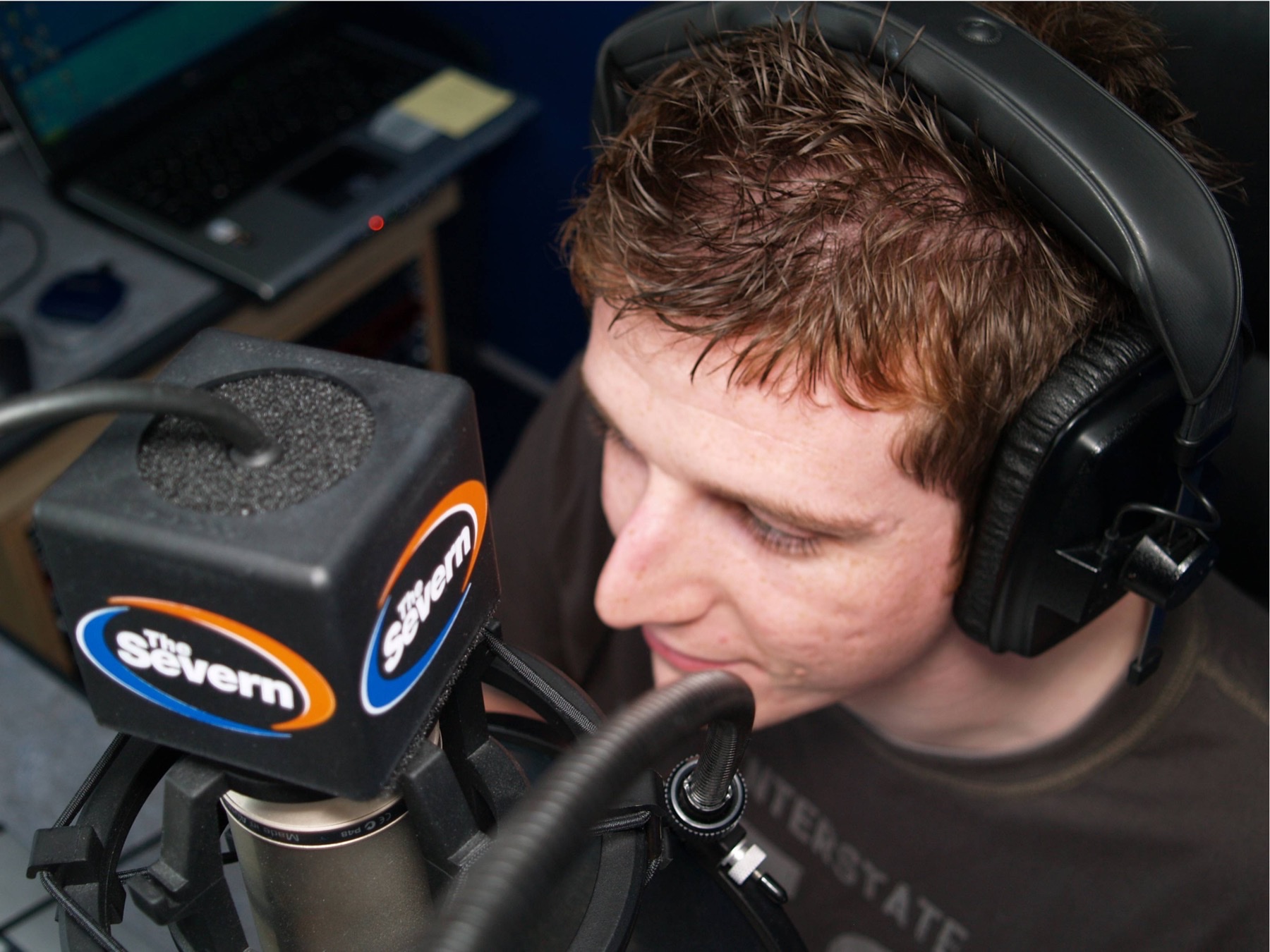 Neil Bentley wearing headphones and speaking into a The Severn radio microphone